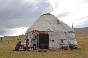 Happy tourists posing against a mountain landscape in Kyrgyzstan